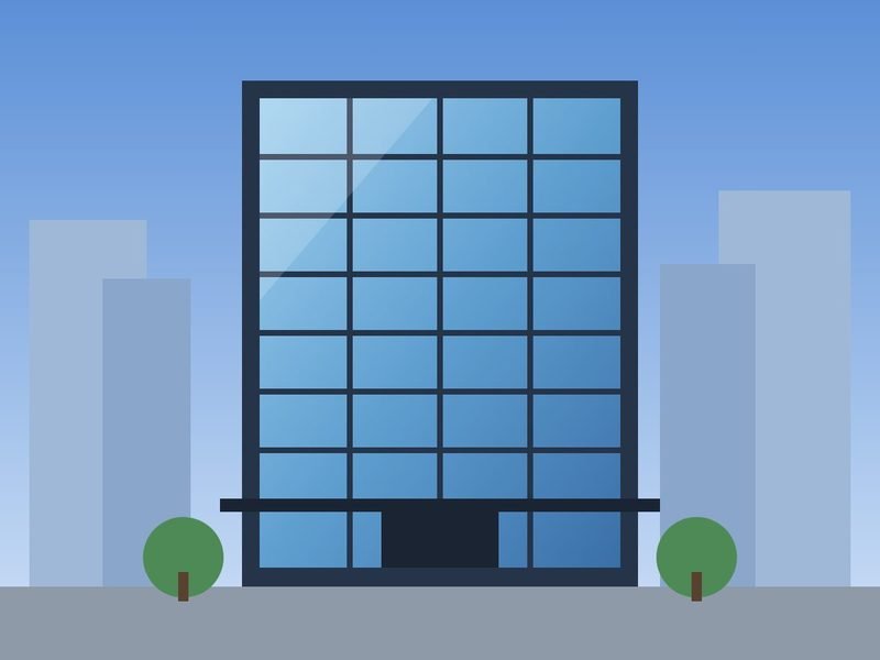 Eight-storey glass office tower against a blue sky, between lower buildings